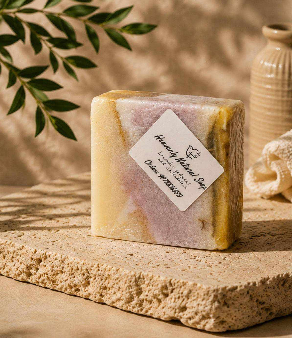 Soap bar in marbled cream, lavender, and golden hues, with a handcrafted appearance and a paper label; Lavender Oatmeal and Calendula