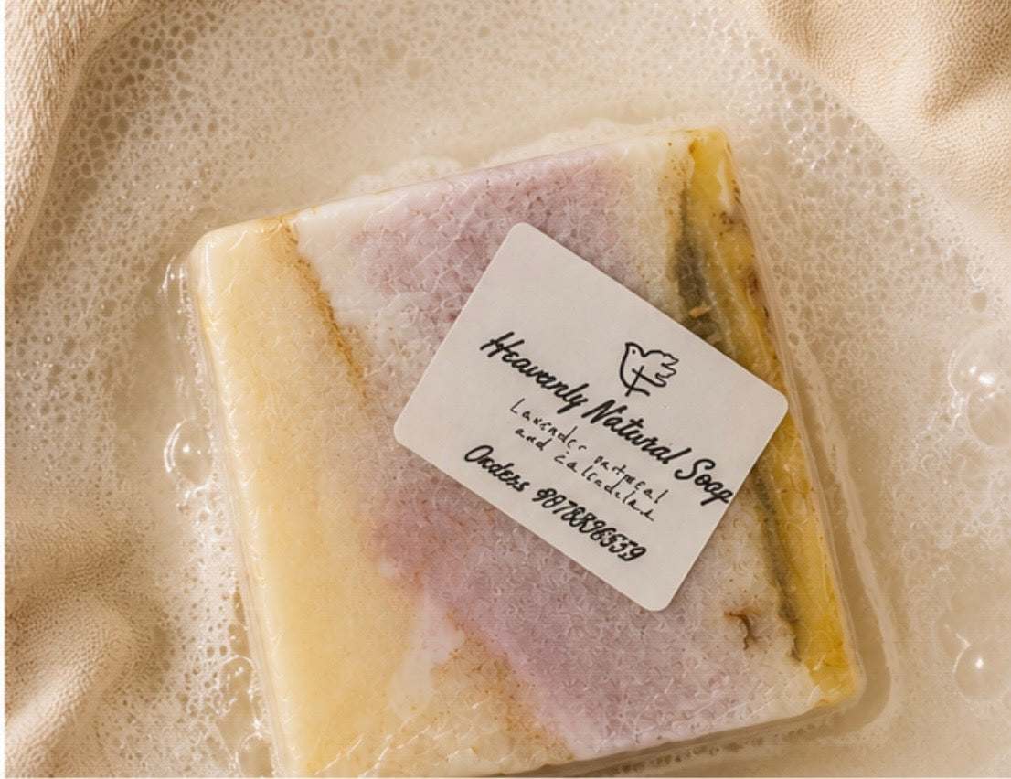 Lavender Oatmeal and Calendula soap bar with a cream, pink and yellow marbled pattern and a paper label