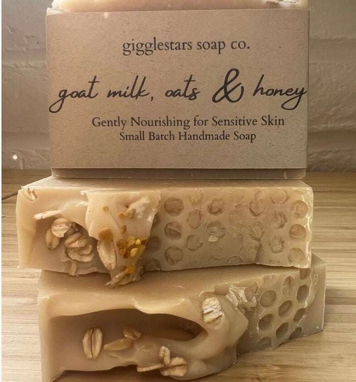 Oatmeal Scrub Soapbar in beige handmade bars with visible oats and a kraft label reading goat milk, oats and honey