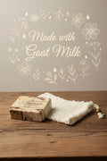 Rice cinnamon soap bar with a speckled brown surface, wrapped in a cream paper label and showing a handmade appearance